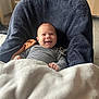 Jules a rejoint le concours — aidez-le/la à gagner de superbes lots ! baby, smiling, blanket, striped_clothing, pacifier, chair, cushion, indoor, floor_tiles, cabinet, toy, happy, infant, cozy, child, portrait, comfort, furniture, warm, cute