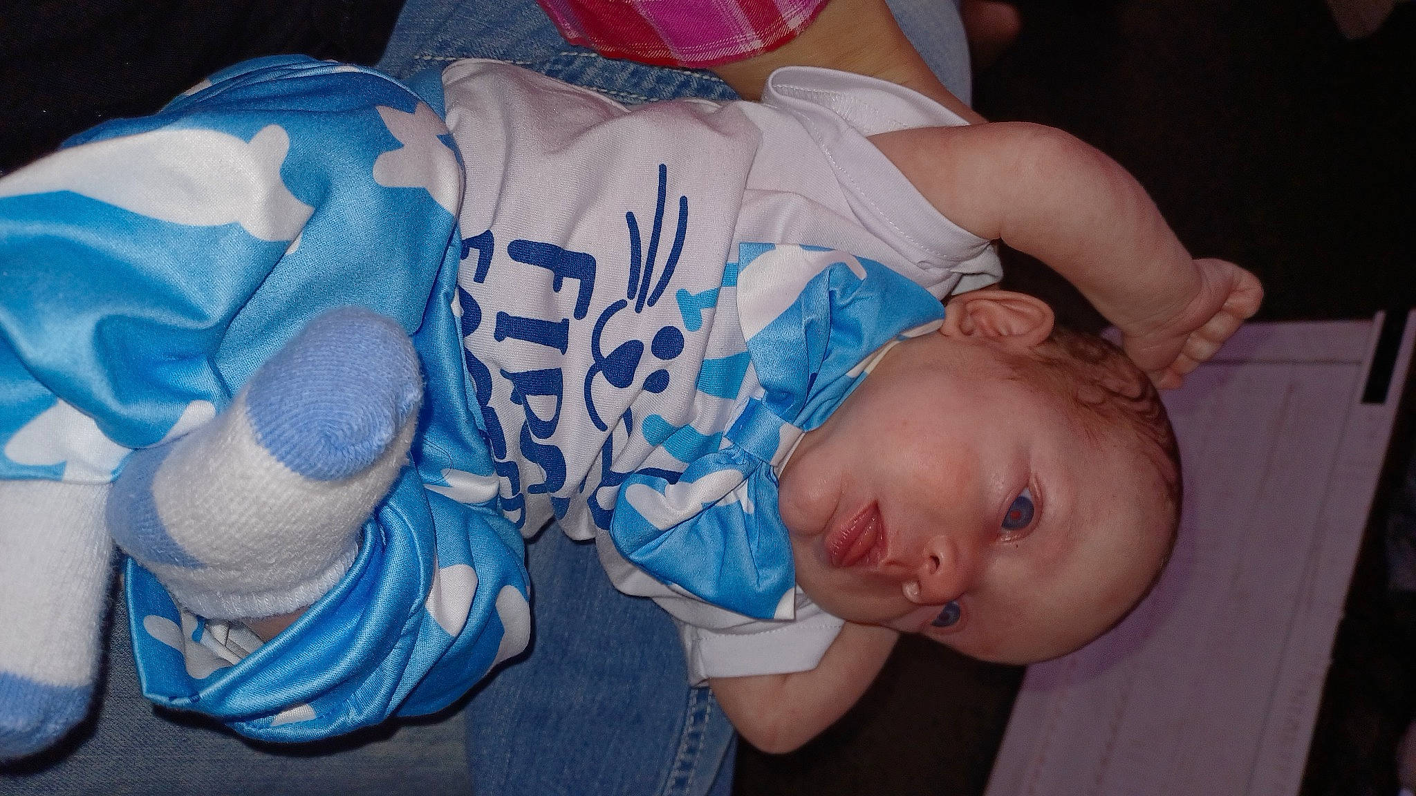 Bentley is registered to the contest to win money with this photo: arm, baby, baby_products, baby_toddler_clothing, child, comfort, elbow, electric_blue, finger, fun, glasses, hand, headgear, human_body, mouth, person, sitting, t_shirt, thigh, toddler