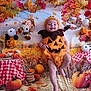 Filip a rejoint le concours — aidez-le/la à gagner de superbes lots ! baby, pumpkin_costume, fall, autumn, leaves, pumpkins, hay, scarecrow, smiling, festive, costume, child, outdoor_theme, orange, yellow, red, plush, portrait, celebration, cute