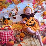 autumn, baby, background, black_pinecone, checkered_cloth, child, cute, fall_leaves, festive, hay_bale, holiday, orange, outfit, playful, portrait, pumpkin_costume, scarecrow, seasonal, smiling, white_pumpkin