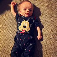baby, clothing, couch, cushion, face, furniture, head, homedecor, newborn, pajamas, pants, person, photography, portrait, quilt, sitting, sleeping, sleeve, t_shirt, yawning