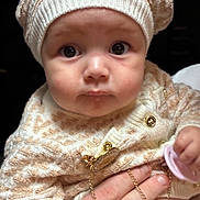 Dallas joined the competition — help win amazing prizes! baby, infant, face, hat, knitwear, sweater, pacifier, hand, child, closeup, portrait, cute, warm_clothing, gold_chain, expression, skin, eyes, indoor, person, young_child