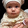 baby, infant, face, hat, knitwear, sweater, pacifier, hand, child, closeup, portrait, cute, warm_clothing, gold_chain, expression, skin, eyes, indoor, person, young_child
