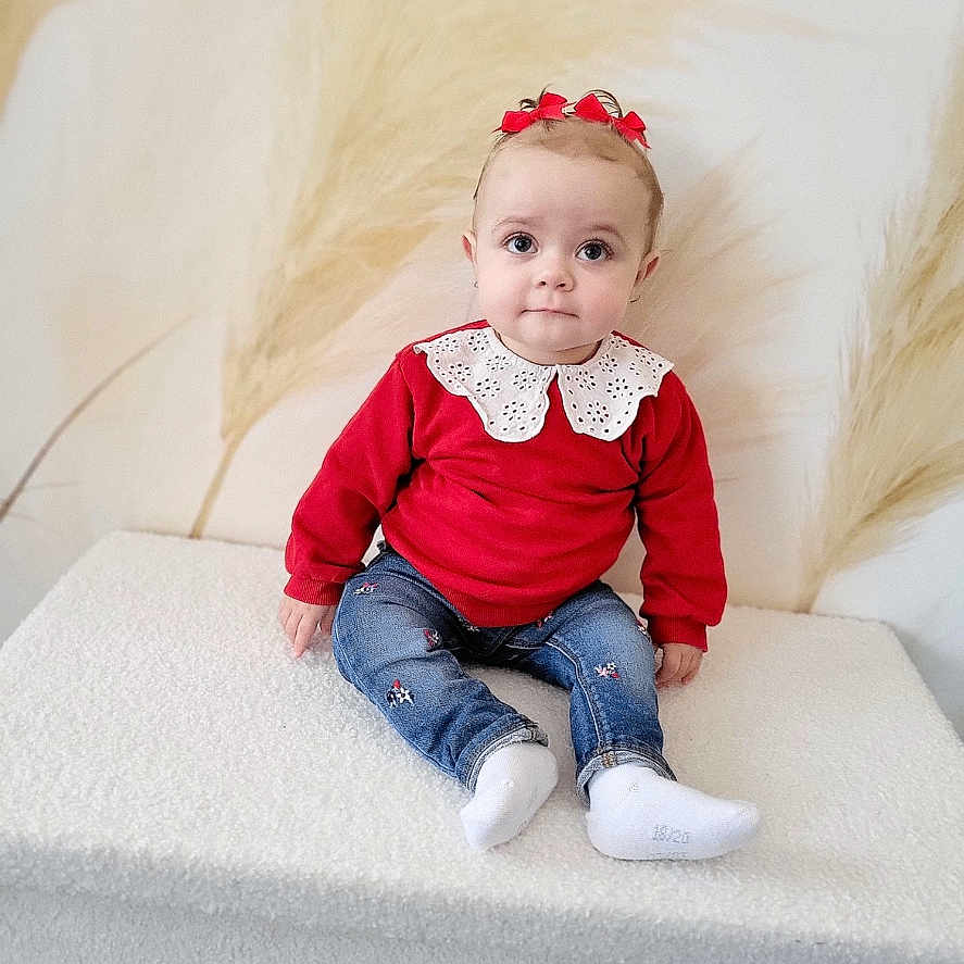 émy Provenier participe au concours pour gagner de l'argent avec cette photo : baby, casual_clothing, child, curious, cute, headband, indoor, innocence, jeans, lace_collar, pampas_grass, portrait, red_sweater, sitting, small_bows, smiling, soft_surface, toddler, white_socks, young_child