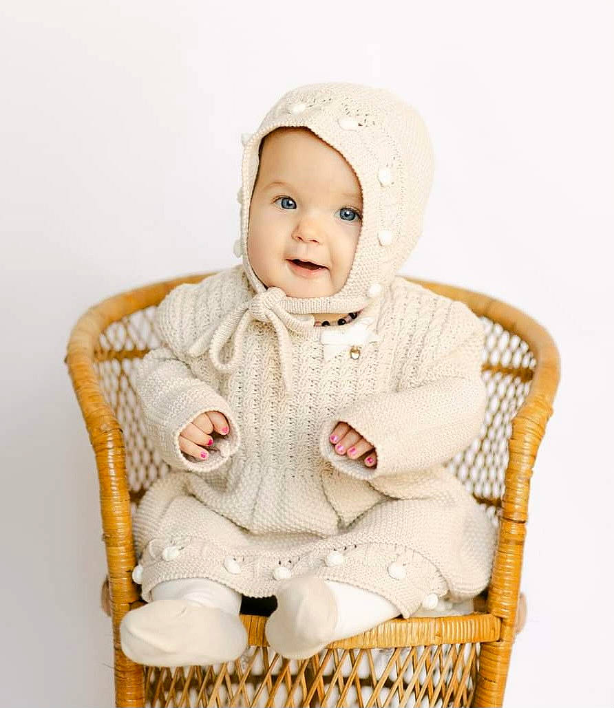 Graciemae is registered to the contest to win money with this photo: baby, baby_toddler_clothing, cap, chair, child, collar, comfort, face, fashion_accessory, formal_wear, fur, happy, headwear, outerwear, pattern, person, sitting, sleeve, smile, toddler