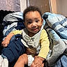 Zamir is registered to the contest to win money with this photo: baby, smiling, bib, blanket, diaper, indoor, child, cute, happy, clothing, sitting, portrait, infant, furniture, cozy, soft, young, person, sock, hand
