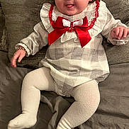 Lanesra joined the competition — help win amazing prizes! baby, child, infant, cute, smiling, tongue_out, red_bow, checkered_outfit, white_tights, bracelet, bed, pillow, cozy, indoor, portrait, happy, playful, person, young_child, face