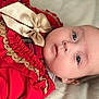 baby, infant, face, blue_eyes, red_clothing, bow, frills, portrait, closeup, skin, head, laying_down, cute, child, young, soft_background, expression, person, indoors, newborn