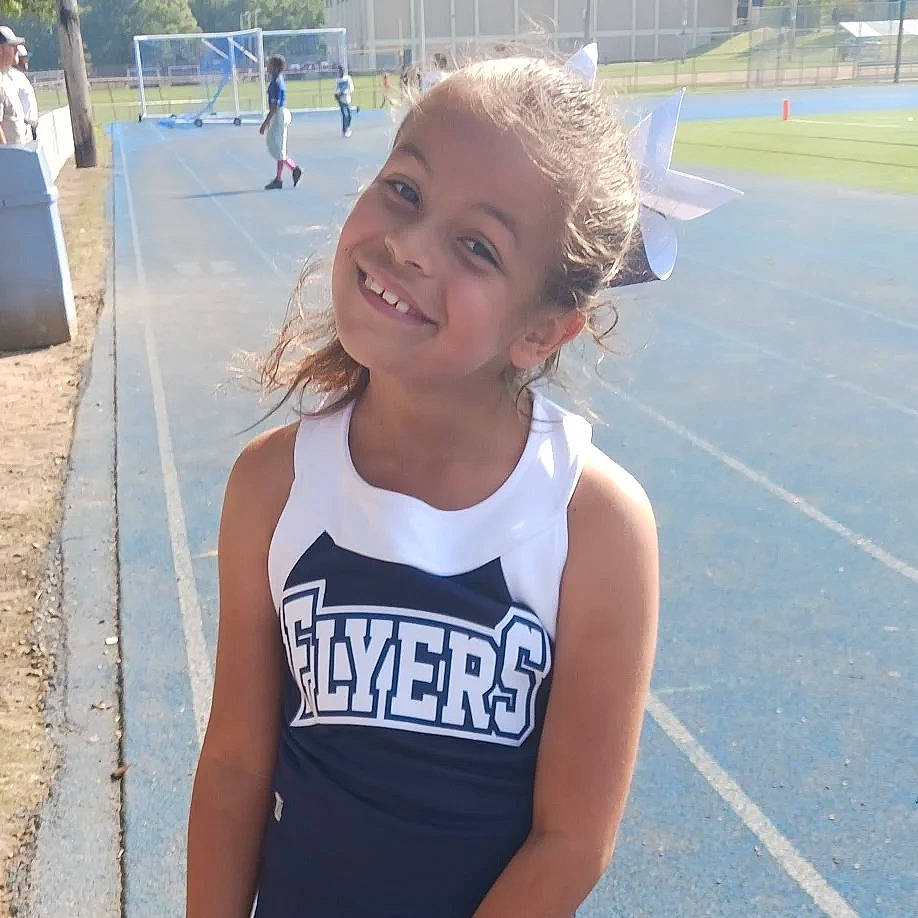 Maria is registered to the contest to win money with this photo: active_tank, asphalt, blond, chest, electric_blue, fun, grass, hair, happy, jersey, joy, leisure, person, recreation, sleeveless_shirt, smile, sports_uniform, sportswear, t_shirt, toddler