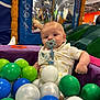 baby, ball_pit, child, childcare, clothing, colorful_balls, curious, fun, indoor_playground, infant, leisure, netting, pacifier, padded_walls, plastic_balls, play_area, playtime, seated, soft_play, yellow_sun_pattern