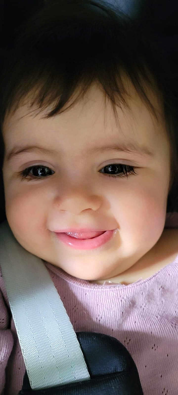 Celine participe au concours pour gagner de l'argent avec cette photo : baby, child, face, smile, tongue, pink_clothing, strap, close_up, cute, young, infant, person, eyelashes, soft_light, happy, cheeks, dark_hair, indoors, portrait, skin