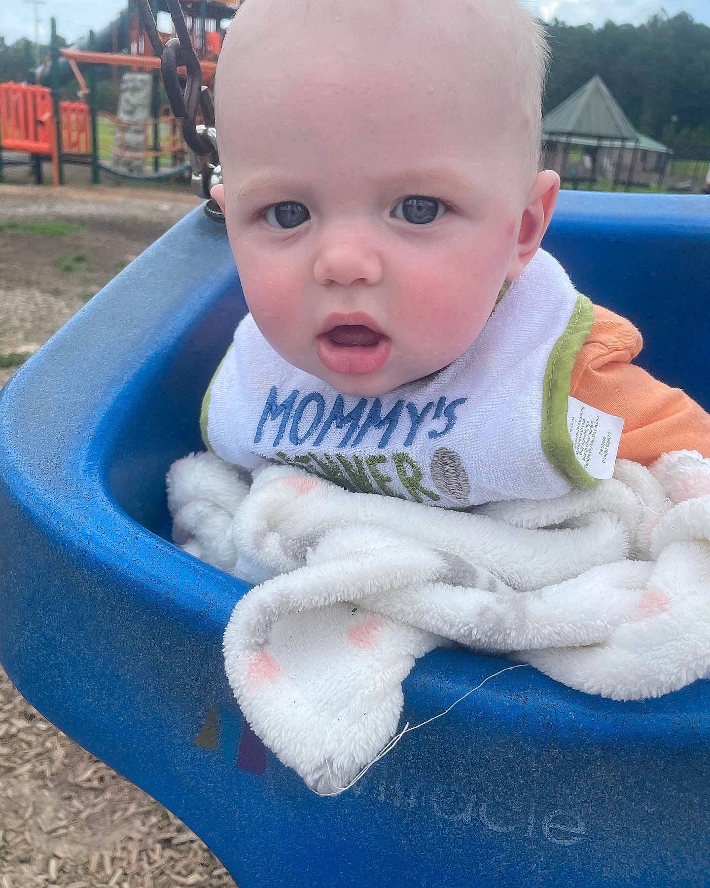 Dawson is registered to the contest to win money with this photo: automotive_tire, baby, baby_products, baby_toddler_clothing, blue, cheek, child, fun, grass, happy, leisure, person, plant, product, sitting, skin, sky, soil, toddler, tree