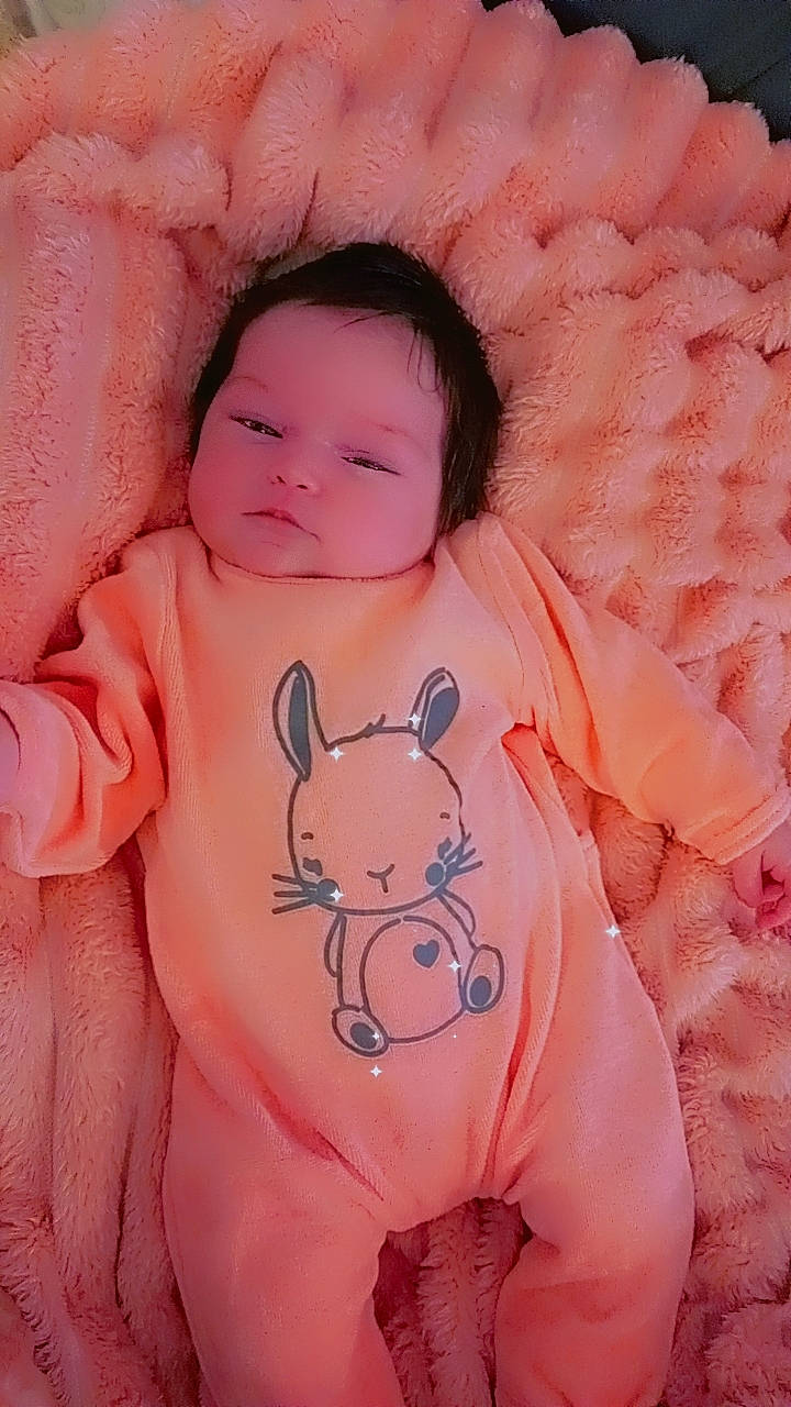 Evelyna participe au concours pour gagner de l'argent avec cette photo : baby, baby_toddler_clothing, cheek, eye, face, finger, happy, head, iris, lip, mammal, mouth, neck, nose, orange, person, pink, product, skin, sleeve