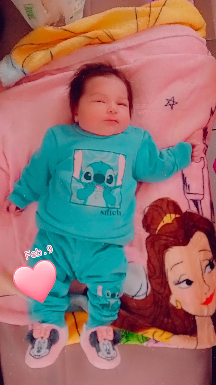 Evelyna participe au concours pour gagner de l'argent avec cette photo : aqua, azure, baby, baby_toddler_clothing, cheek, comfort, facial_expression, happy, head, human, mouth, orange, organ, person, pink, product, skin, sleeve, textile, white