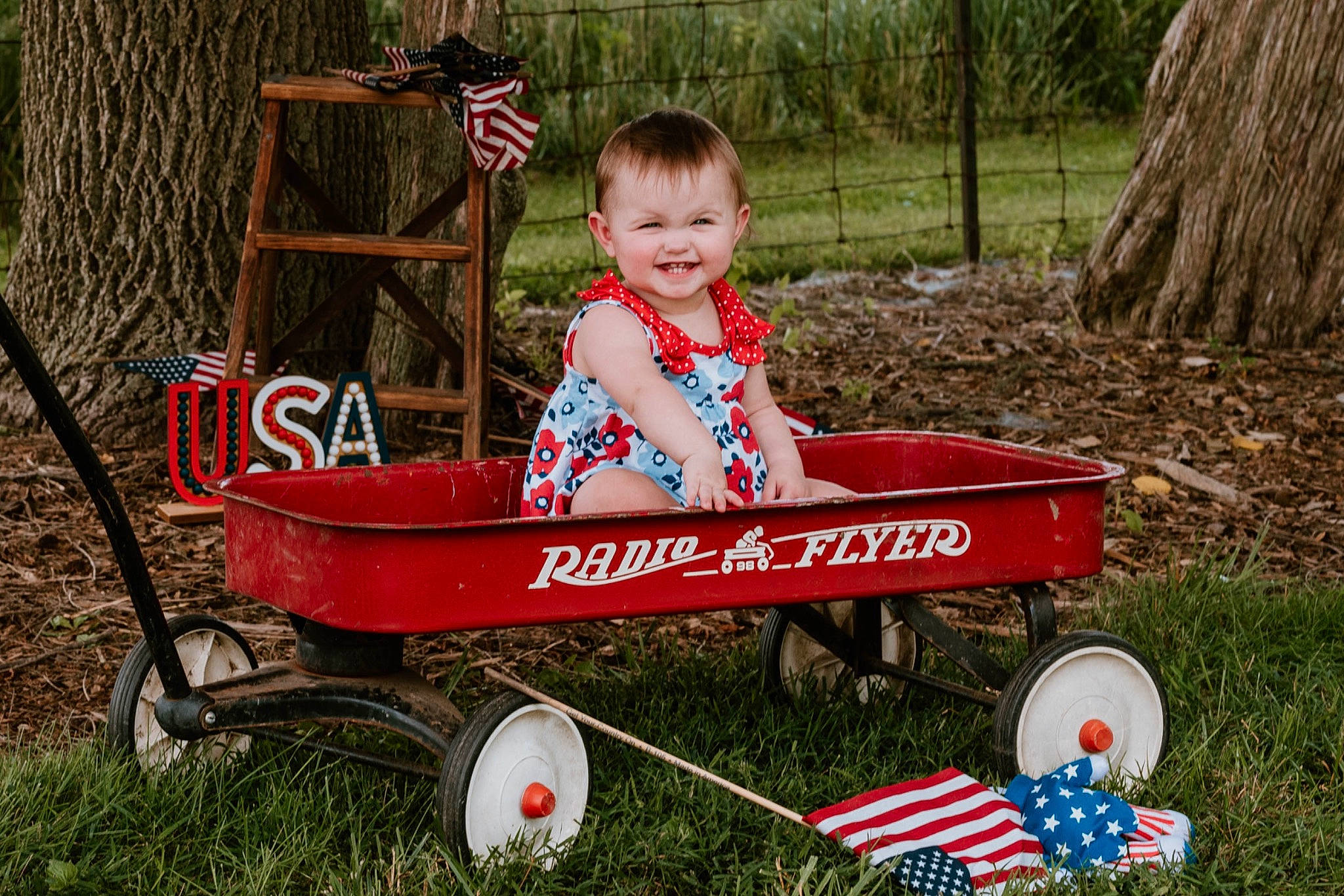 Davina is registered to the contest to win money with this photo: automotive_wheel_system, child, fun, grass, happy, joy, leisure, people_in_nature, person, plant, play, recreation, smile, soil, tire, toddler, toy, tree, vehicle, wheel