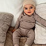 baby, child, pajamas, hat, smile, couch, pillow, blanket, indoor, cozy, cute, infant, sitting, soft, comfortable, person, young, warm, relaxed, home