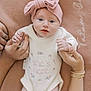 Tatum joined the competition — help win amazing prizes! baby, infant, pink_bow, white_sweater, hands, blanket, blue_eyes, cute, newborn, holding_hands, soft_texture, portrait, child, family, skin, nails, bracelets, buttoned_clothing, lying_down, close_up