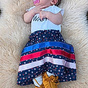 Lilly is registered to the contest to win money with this photo: baby, sleeping, pacifier, headband, flower, white_top, striped_skirt, moccasins, yellow_shoes, fluffy_rug, outdoor, grass, infant, cute, peaceful, child, soft_texture, female, clothing, portrait