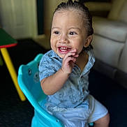 Jonathan is registered to the contest to win money with this photo: toddler, child, smiling, happy, indoor, chair, blue_chair, clothing, shorts, shirt, person, face, hair, hand, playful, cute, seated, home, furniture, expression