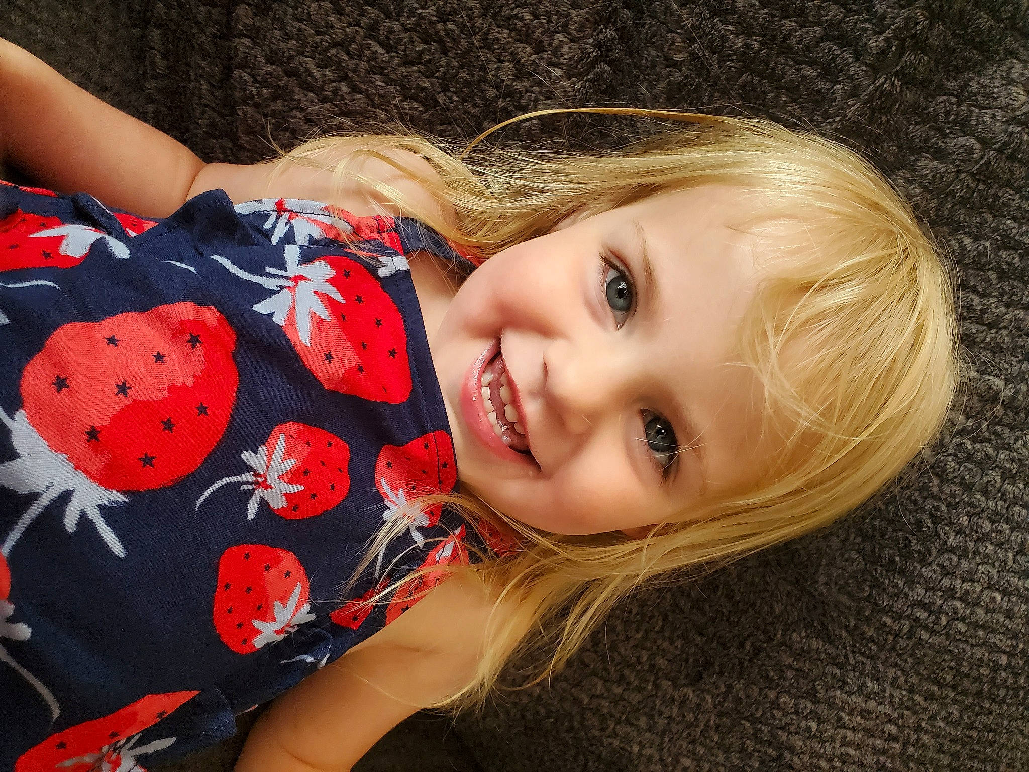 Paislee is registered to the contest to win money with this photo: brown_hair, carmine, cheek, child, elbow, flash_photography, grass, happy, human_leg, joy, lip, long_hair, pattern, person, plaid, plant, sitting, skin, smile, toddler