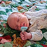 baby, newborn, infant, sleeping, pacifier, blanket, quilt, bed, portrait, face, hand, fingers, clothing, onesie, cartoon, animals, patterned_fabric, indoors, cozy, closeup