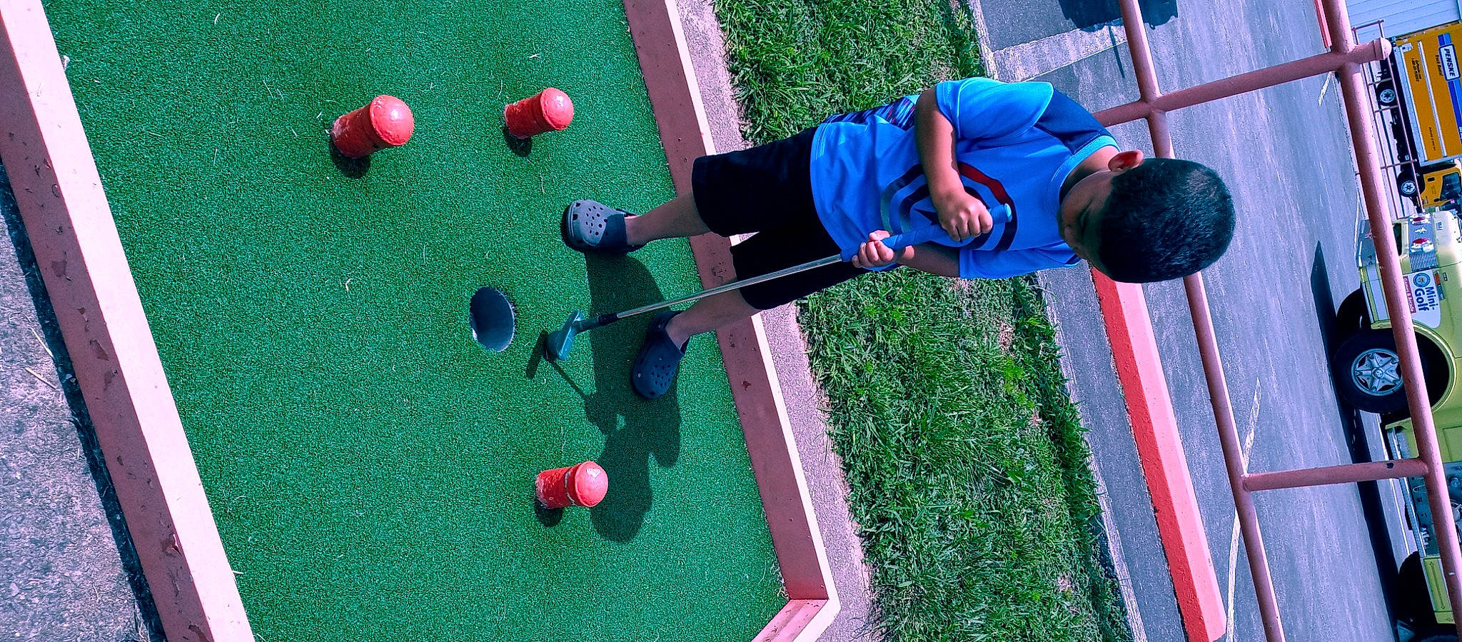 Jalen is registered to the contest to win money with this photo: ball, ball_game, blue, competition_event, fun, golf, golf_ball, golf_equipment, grass, green, lawn, leisure, line, miniature_golf, outdoor_recreation, person, precision_sports, recreation, sports, sports_equipment