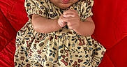 Arianna is registered to the contest to win money with this photo: baby, infant, child, floral_dress, headband, red_background, clapping_hands, tongue_out, cute, lying_down, adorable, playful, white_tights, portrait, young_child, closeup, smiling, person, indoors, fashion