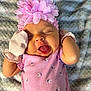 Amari joined the competition — help win amazing prizes! baby, infant, pink_clothing, flower_headband, mittens, tongue_out, sleepy, soft_blanket, cute, closeup, portrait, child, newborn, pink, fabric, texture, lying_down, cozy, small_flower_print, adorable