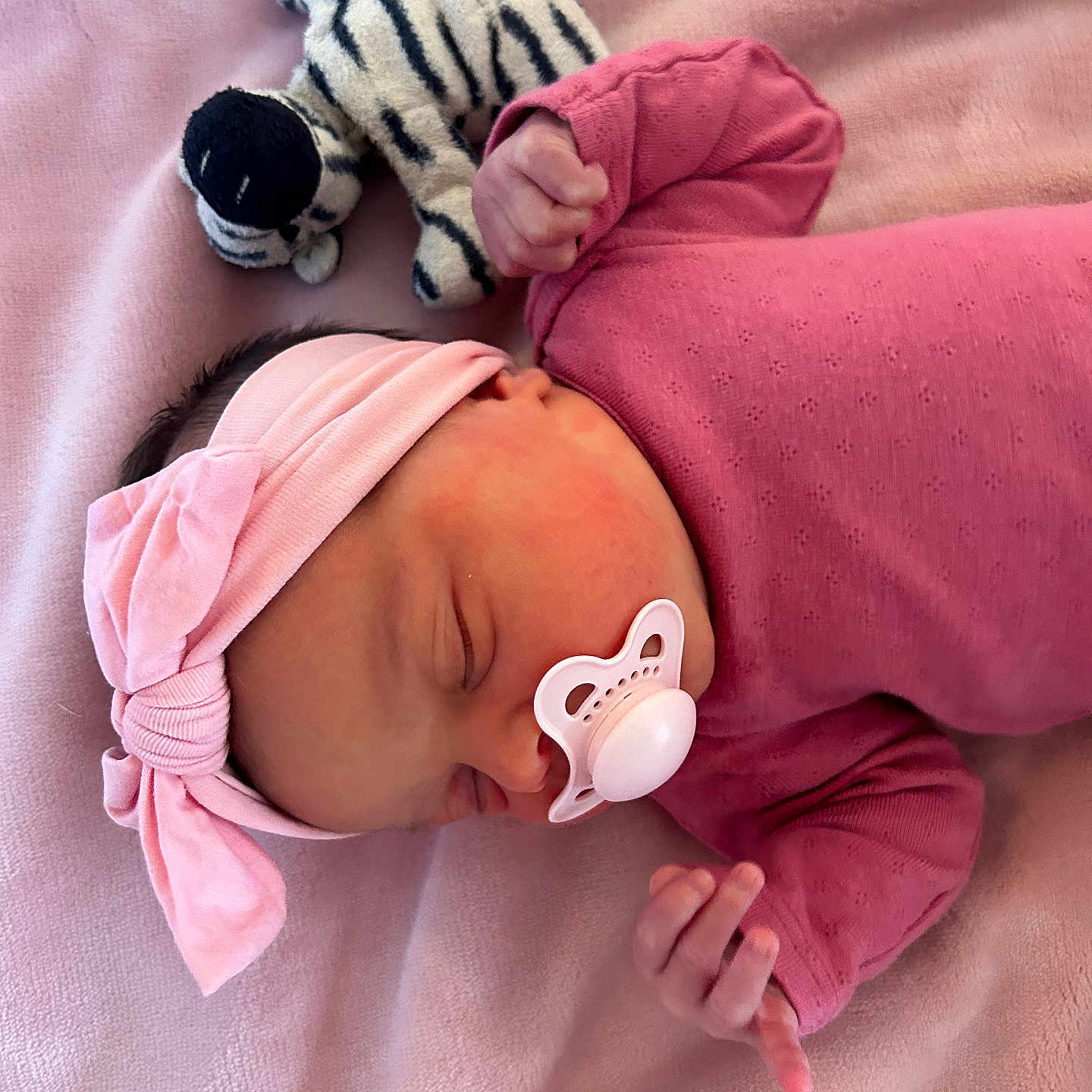 Amari joined the competition — help win amazing prizes! adorable, baby, child, cozy, cute, headband, indoors, infant, newborn, pacifier, peaceful, pink_blanket, pink_clothing, plush_toy, portrait, resting, sleeping, small_hands, soft_texture, zebra_pattern