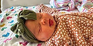 Amari joined the competition — help win amazing prizes! baby, sleeping, headband, floral_clothing, blanket, duck_pattern, striped_cloth, infant, cute, peaceful, soft_texture, bed, newborn, child, face, mouth_open, indoor, portrait, resting, cozy