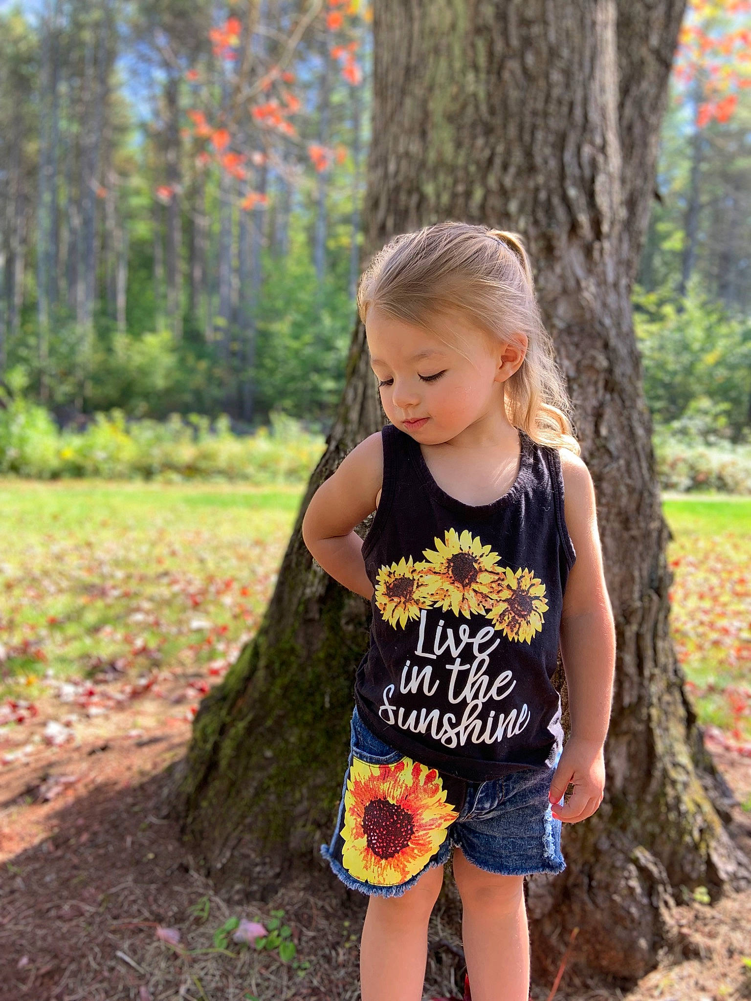 Luna is registered to the contest to win money with this photo: beauty, blond, child, grass, happy, long_hair, orange, people_in_nature, person, plant, sleeve, smile, summer, t_shirt, thigh, toddler, tree, trunk, waist, wood