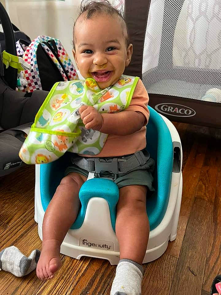 Kamari joined the competition — help win amazing prizes! baby, baby_toddler_clothing, child, comfort, facial_expression, foot, fun, green, happy, head, human_leg, joy, knee, lap, leisure, person, shorts, sitting, smile, thigh