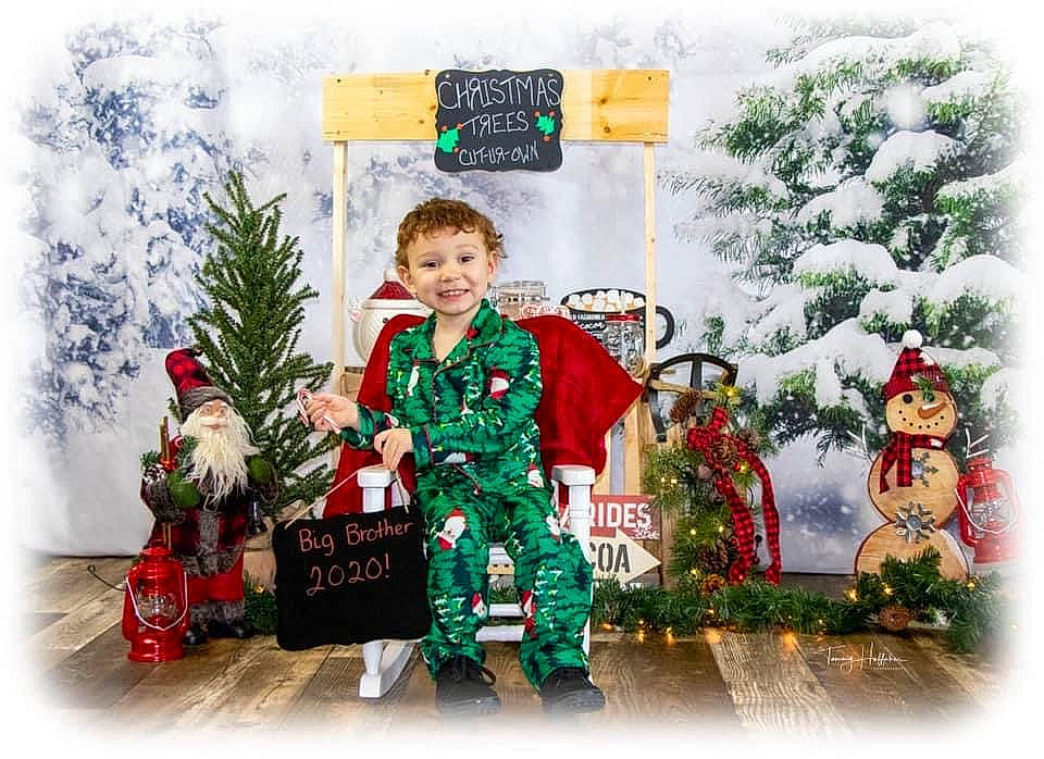 Braxton is registered to the contest to win money with this photo: christmas, christmas_decoration, christmas_eve, christmas_ornament, christmas_tree, conifer, event, evergreen, fictional_character, hat, holiday, holiday_ornament, joy, ornament, person, plant, santa_claus, sleeve, smile, tradition