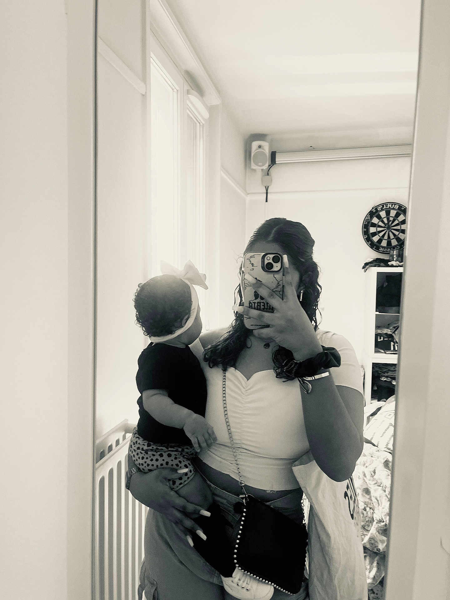 Virginia Sousa a rejoint le concours — aidez-le/la à gagner de superbes lots ! baby, child, woman, mirror, selfie, phone, headband, bow, black_and_white, indoor, room, curly_hair, clothing, purse, furniture, dartboard, shelf, casual, portrait, holding