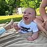 Kayson is registered to the contest to win money with this photo: baby, infant, smiling, outdoor, blanket, grass, greenery, sunlight, person, shirt, levis, happy, child, nature, portrait, skin, hand, face, blue_eyes, sitting