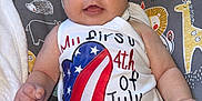 Kenidy is registered to the contest to win money with this photo: baby, infant, red_bow, headband, 4th_of_july, patriotic_clothing, dress, sitting, cushion, elephant, giraffe, lion, happy_baby, indoor, smiling, cute, child, face, white_clothing, american_flag_pattern