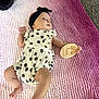 Kenidy is registered to the contest to win money with this photo: baby, infant, headband, romper, floral_pattern, blanket, pink, purple, wooden_sign, two_months_old, lying_down, carpet, cute, child, person, indoors, soft_texture, hand, foot, portrait