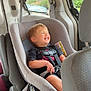 Meeko is registered to the contest to win money with this photo: toddler, child, car_seat, smiling, happy, vehicle_interior, seatbelt, window, suburban, house, car, road_trip, safety, child_safety, casual_clothing, shorts, black_shirt, daylight, seat, interior