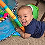 Kaleo is registered to the contest to win money with this photo: baby, infant, child, smile, tongue_out, play_mat, colorful_balls, toy, carpet, crawling, hand, face, eyes, clothing, indoor, living_room, playtime, fabric, happiness, person
