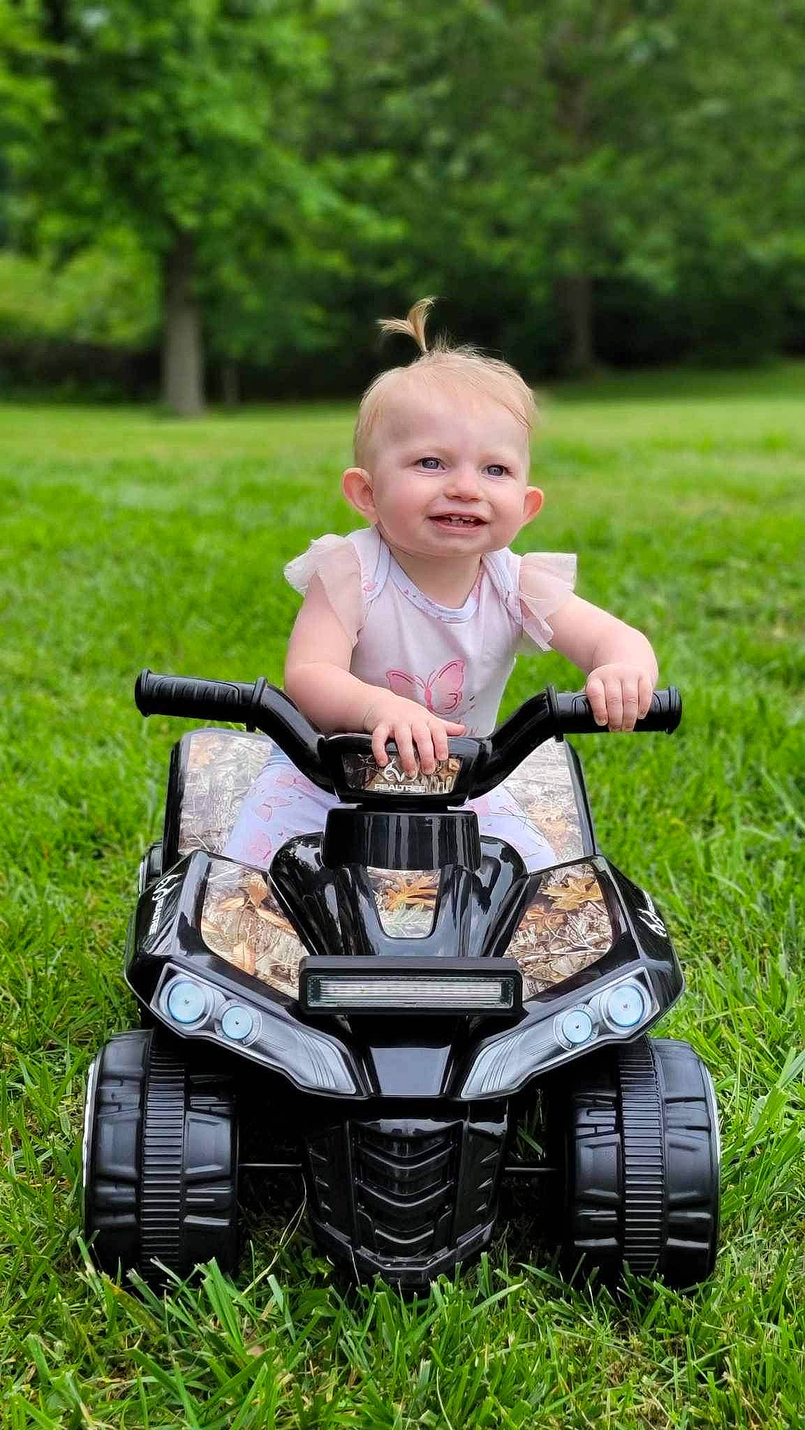 Jocelyn joined the competition — help win amazing prizes! automotive_design, automotive_exterior, automotive_lighting, automotive_tire, automotive_wheel_system, bumper, grass, happy, joy, motor_vehicle, people_in_nature, person, photograph, plant, smile, tire, toddler, toy, tread, tree