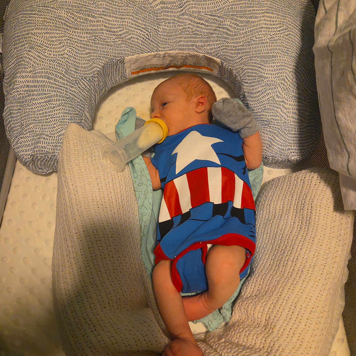 Riley is registered to the contest to win money with this photo: baby, infant, bottle, feeding, blanket, pillow, cushion, clothing, onesie, person, sleeping, resting, cute, small, newborn, indoors, soft, comfort, lying_down, child