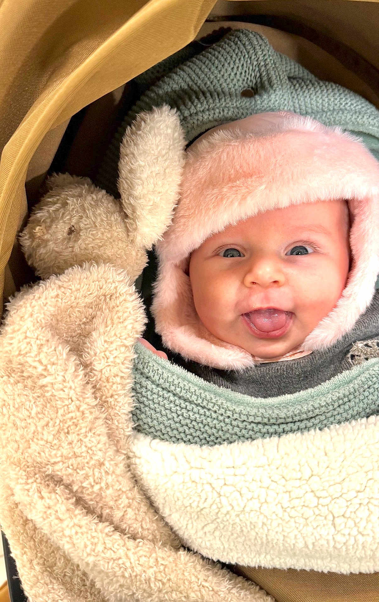 Alba participe au concours pour gagner de l'argent avec cette photo : baby, face, tongue, hat, knitwear, plush_toy, bunny, blanket, cozy, smile, child, cute, infant, warm, soft, cute_expression, person, portrait, indoors, snuggled