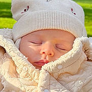 Alba a rejoint le concours — aidez-le/la à gagner de superbes lots ! baby, sleeping, hat, jacket, outdoor, greenery, child, face, closeup, winter_clothing, knitwear, peaceful, sunlight, portrait, infant, soft_texture, cozy, nature, cute, warm