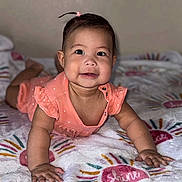 Leah is registered to the contest to win money with this photo: baby, infant, child, smiling, lying_down, blanket, pink_clothing, cute, portrait, indoors, skin, face, hair, hand, person, young_child, happy, bright, colorful, toddler