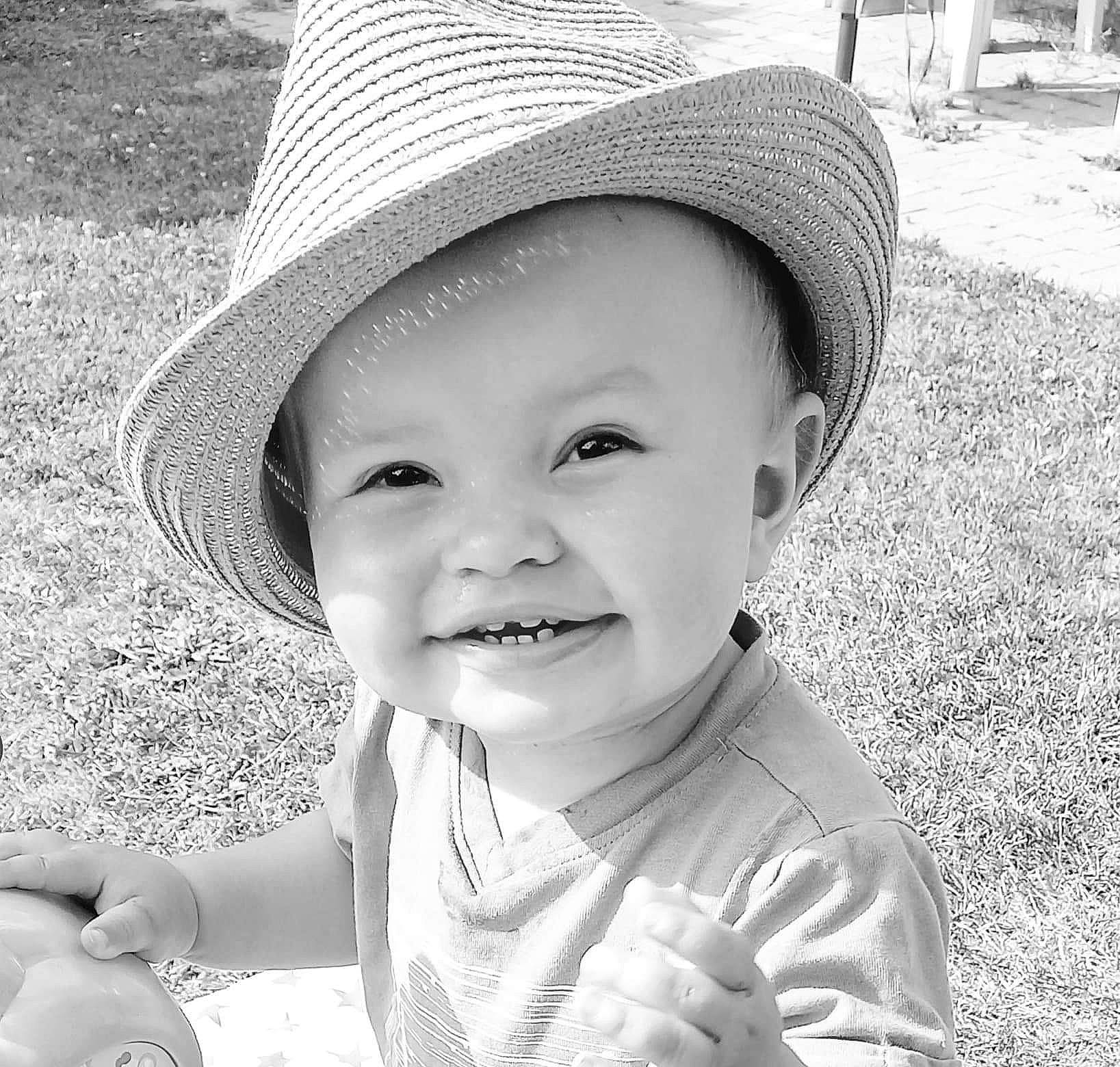 Hugo a rejoint le concours — aidez-le/la à gagner de superbes lots ! baby, black, black_and_white, child, cool, eye, facial_expression, gesture, grass, happy, hat, headgear, joy, people_in_nature, person, photograph, skin, smile, style, sun_hat