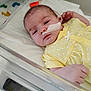 baby, infant, hospital, crib, feeding_tube, yellow_clothing, polka_dots, blanket, newborn, medical, patient, tape, bed, resting, child, healthcare, cute, face, human, sleepy