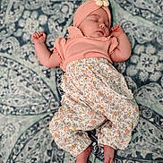 Rosie is registered to the contest to win money with this photo: baby, sleeping, infant, headband, flower, patterned_blanket, peach_top, floral_pants, bare_feet, cute, peaceful, portrait, child, soft_lighting, indoor, resting, adorable, small_hands, cozy, relaxed