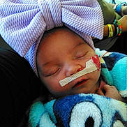 Rosie joined the competition — help win amazing prizes! baby, sleeping, bow, headband, nasal_tube, blanket, colorful, cartoon, person, hand, closeup, resting, infant, cute, soft, cozy, child, face, toddler, peaceful