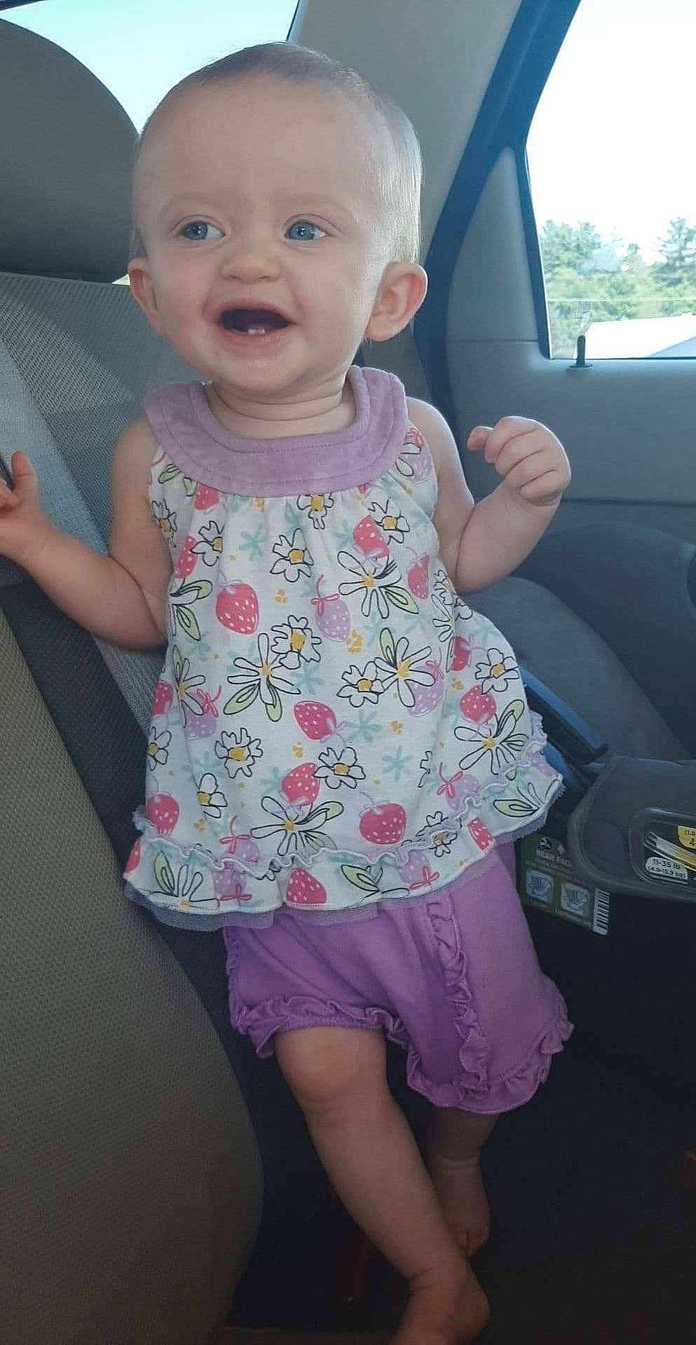 Lois is registered to the contest to win money with this photo: baby, baby_toddler_clothing, car_seat, child, dress, pattern, person, pink, product, skin, smile, toddler