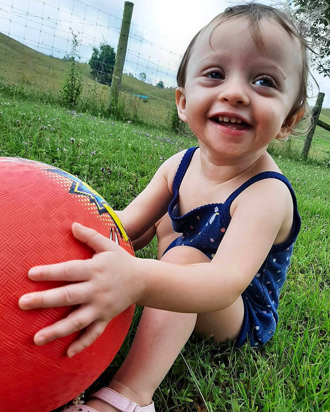 Braeley Rose is registered to the contest to win money with this photo: baby, ball, child, facial_expression, finger, fun, grass, grass_family, hand, happy, joy, lawn, leisure, person, plant, play, skin, smile, summer, toddler
